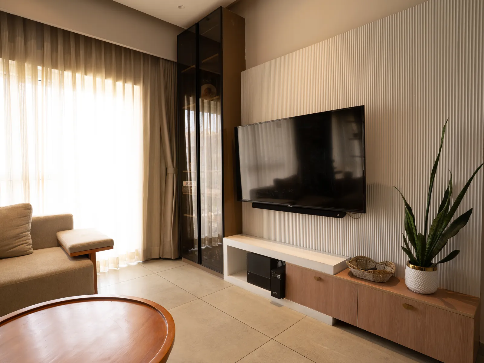 TV wall with fluted panelling and low oak console — Amlan's Residence